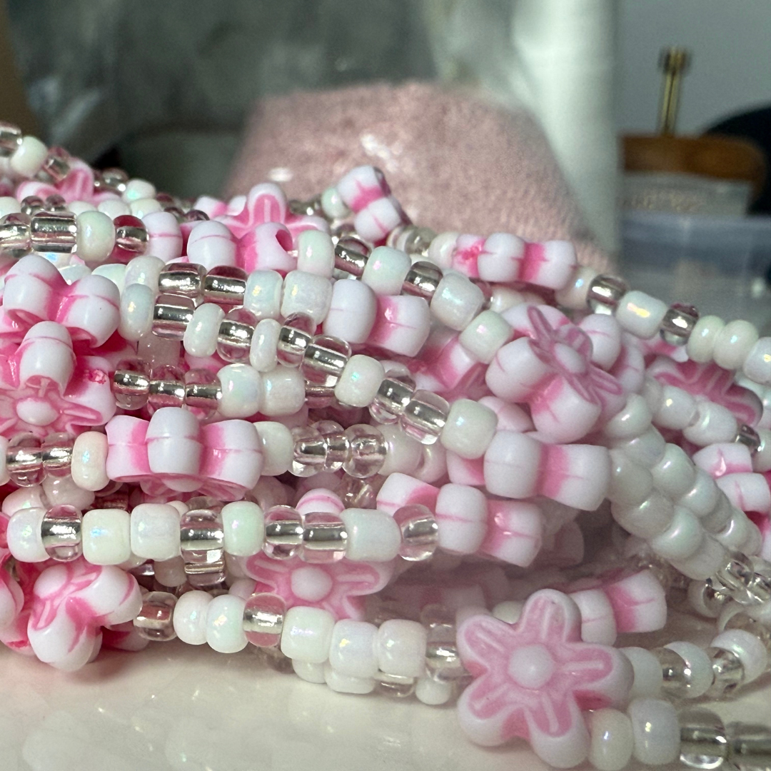 pink and white waist beads with floral designs. waist beads for weight loss